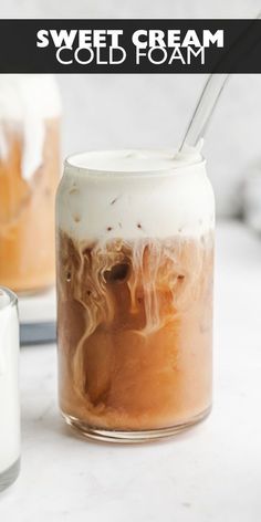 an iced drink in a mason jar next to a glass filled with ice and liquid