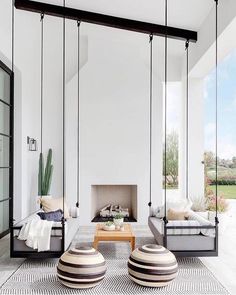 a living room filled with furniture next to a fire place under a skylight in front of a white wall