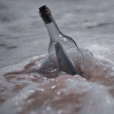 an empty bottle floating in the ocean on top of water with waves coming up around it