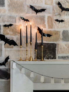 some candles are sitting on a mantle with bats