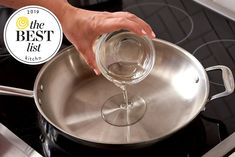 a person is pouring water into a pan on the stove with an award sticker