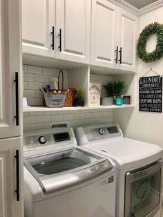 a washer and dryer in a laundry room with white cabinets on the wall