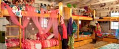 there are many bunk beds in this room with pink curtains on the top and bottom