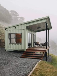 a house made out of shipping containers sitting on top of a hill