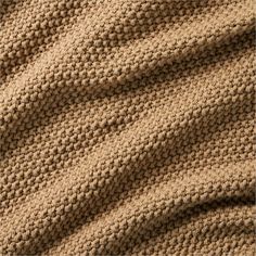 a knitted blanket is shown in beige