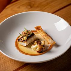 a white plate topped with food on top of a wooden table