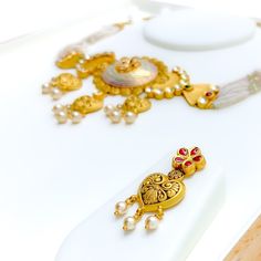 This 22k gold necklace set, weighing 62.1 grams, showcases an imperial and classy floral design with an antique finish, adorned with Kundan and pearl accents. The necklace measures 17 inches in length with a 1.25-inch drop and includes 0.8-inch adjustable links, secured with a hook lock. The set includes matching earrings, each 1.6 inches in length with a screw back post. Ideal for those who appreciate luxurious and timeless jewelry, this set combines the regal elegance of antique gold with the traditional beauty of Kundan and pearls, making it a standout piece perfect for enhancing your personal style. PRODUCT DETAILS Gold Purity(karat): 22k Item Weight(grams): 62.1 Item Finish: Antique Finish Stone: Kundan + Pearl Set Length: 17" Drop Length: 1.25" Adjustable Links: 0.8" Links Lock Style Traditional 22k Gold Pearl Necklace For Festive Occasions, Traditional 22k Yellow Gold Pearl Necklace, 22k Gold Pearl Necklace For Diwali, Gold Antique Necklace, 22k Gold Necklace Set, Antique Necklace Set, 22k Gold Necklace, Regal Elegance, Bridal Jewelry Necklace