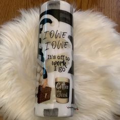 a white coffee mug sitting on top of a fur rug next to a wooden floor