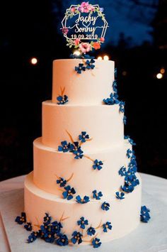 a wedding cake with blue flowers on it