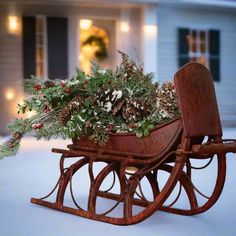 a wooden sleigh filled with plants and pine cones