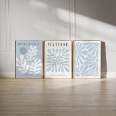 three books sitting on top of a hard wood floor next to each other in front of a white wall