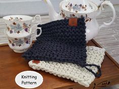 a knitted dishcloth sits on a tray next to teapots and cups