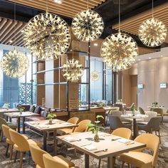 a restaurant with tables, chairs and chandeliers hanging from the ceiling