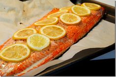 the fish is prepared and ready to be cooked in the oven with lemons on it