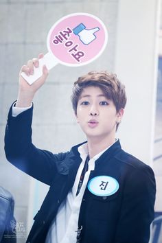 a young man holding up a pink sticker