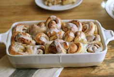 homemade cinnamon rolls from frozen bread dough in a white baking dish on a wooden table