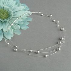 This silver grey floating pearl necklace has been created using light grey Swarovski pearls and Swarovski crystals and designed with bridesmaids/weddings in mind. The neutral tones featured in this three strand illusion necklace would look pretty with almost any colour. These multi-strand necklaces measure 18 inches (46cm) in length and are completed with a silver plated lobster clasp. I will add a 2 inch extender chain to allow you to adjust the length of your pale grey 3 strand necklace to fit Delicate Adjustable Silver Pearl Necklace, Adjustable Silver Pearl Bridal Necklace, Adjustable Silver Pearl Necklace For Wedding, Silver Pearl Necklace With Round Beads For Wedding, Silver Pearl Necklace For Mother Of The Bride, Elegant Gray Necklace For Wedding, Chunky Stone Necklace, Floating Pearl Necklace, Chunky Pearl Necklace