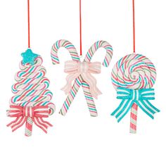 three christmas ornaments hanging from strings with candy canes