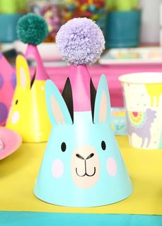 a blue bunny party hat with pom - poms sitting on top of it