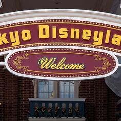 the sign for tokyo disneyland is lit up in red, yellow and white with gold lettering