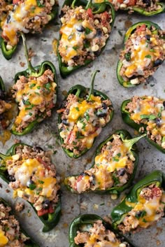 stuffed green peppers with cheese and other toppings on a baking sheet, ready to be eaten