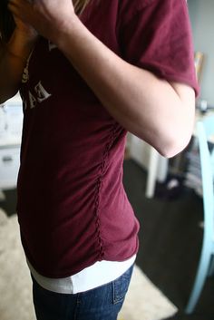 a woman is taking a selfie in the mirror with her cell phone while wearing a maroon shirt