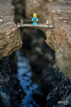 a small toy is sitting on a bridge over water