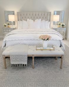 a white bed sitting in a bedroom on top of a rug