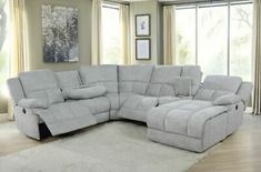 a large sectional couch with reclinings in a living room setting on top of a rug