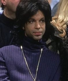 michael jackson is sitting in the stands at a basketball game with his hand on his hip