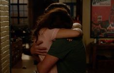 two people hugging each other in a room