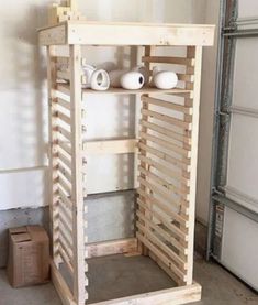 a wooden shelf with two white vases on top of it in a room next to a wall