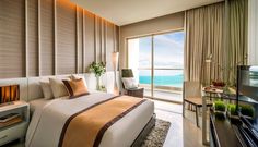 a hotel room with a large bed and ocean view