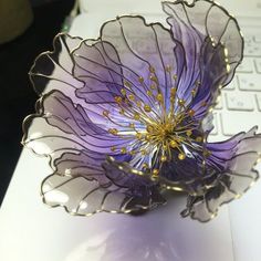 a purple flower sitting on top of a computer keyboard