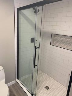 a white toilet sitting next to a walk in shower