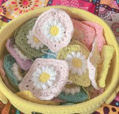 small crocheted flowers in a yellow basket on a colorful cloth covered tablecloth