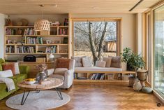 a living room filled with lots of furniture and bookshelves next to a window