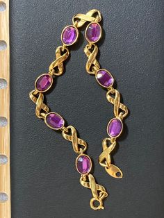 Looking for a stunning vintage bracelet? Check out this AVON gold tone bracelet featuring gorgeous PURPLE amethyst look alike cabochons in an infinity link design.  Perfect for both office wear and dinner parties, it's versatile and stylish. **Details - 8" long x 1/4" wide - Clasp in good working order - Elegant dainty vintage estate jewelry - Well taken care of, no visible damage or discoloration - All fashion gems are securely seated and in good condition - 6 beautiful faux amethyst stones - C Gold Amethyst Bracelets For Formal Occasions, Amethyst Stones, Link Design, Vintage Bracelet, Vintage Avon, Vintage Bracelets, Dinner Parties, Amethyst Stone, Exquisite Jewelry