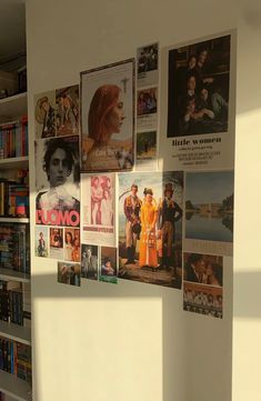 there are many pictures on the wall in this room with bookshelves and magazines