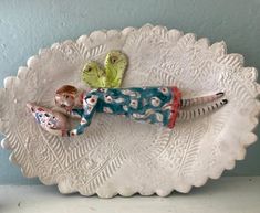 a ceramic plate with a doll laying on it