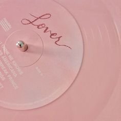 a pink record with the word love written on it and a small silver ball in the middle