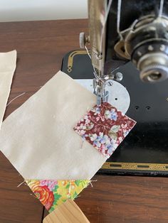 the sewing machine is next to some pieces of fabric that have been sewn together