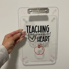 a person holding a clipboard with the words teaching is power of heart written on it