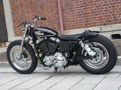 a black motorcycle parked next to a brick building