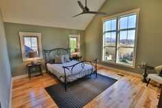 a bedroom with hardwood floors and two windows in the ceiling, along with a bed