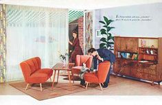 an old photo of two people in a living room with orange chairs and a coffee table