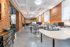 an empty office with brick walls and desks