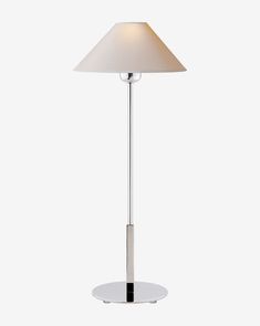 a lamp that is on top of a white table with a light shade over it