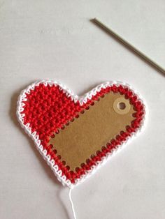 a red and white heart shaped ornament with a hole in the shape of a heart