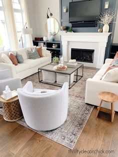 a living room filled with furniture and a flat screen tv mounted on the wall above a fireplace